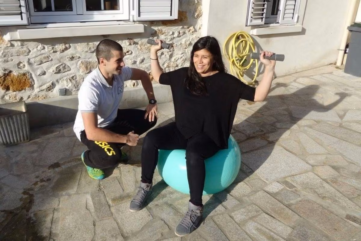 Séance en duo sur ballons de gym devant une maison en pierre