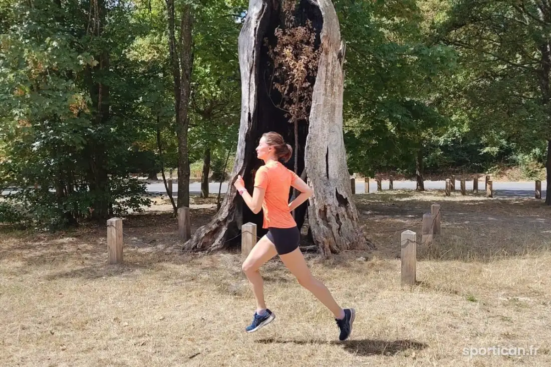 Femme qui court à allure modérée en forêt
