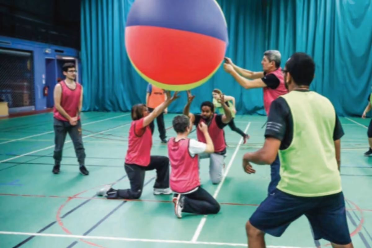 Jeu collectif avec ballon géant dans un gymnase, multisport adultes