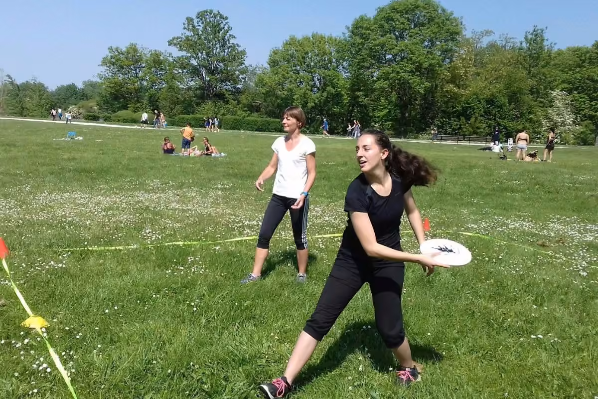 Deux participantes jouant au frisbee sur une pelouse en été