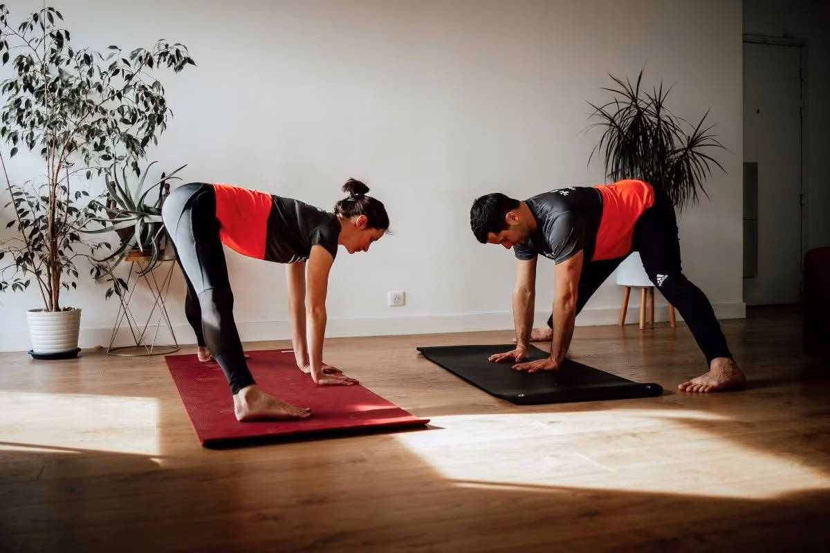 Posture du chien tête en bas sur tapis pendant une séance de Pilates à domicile