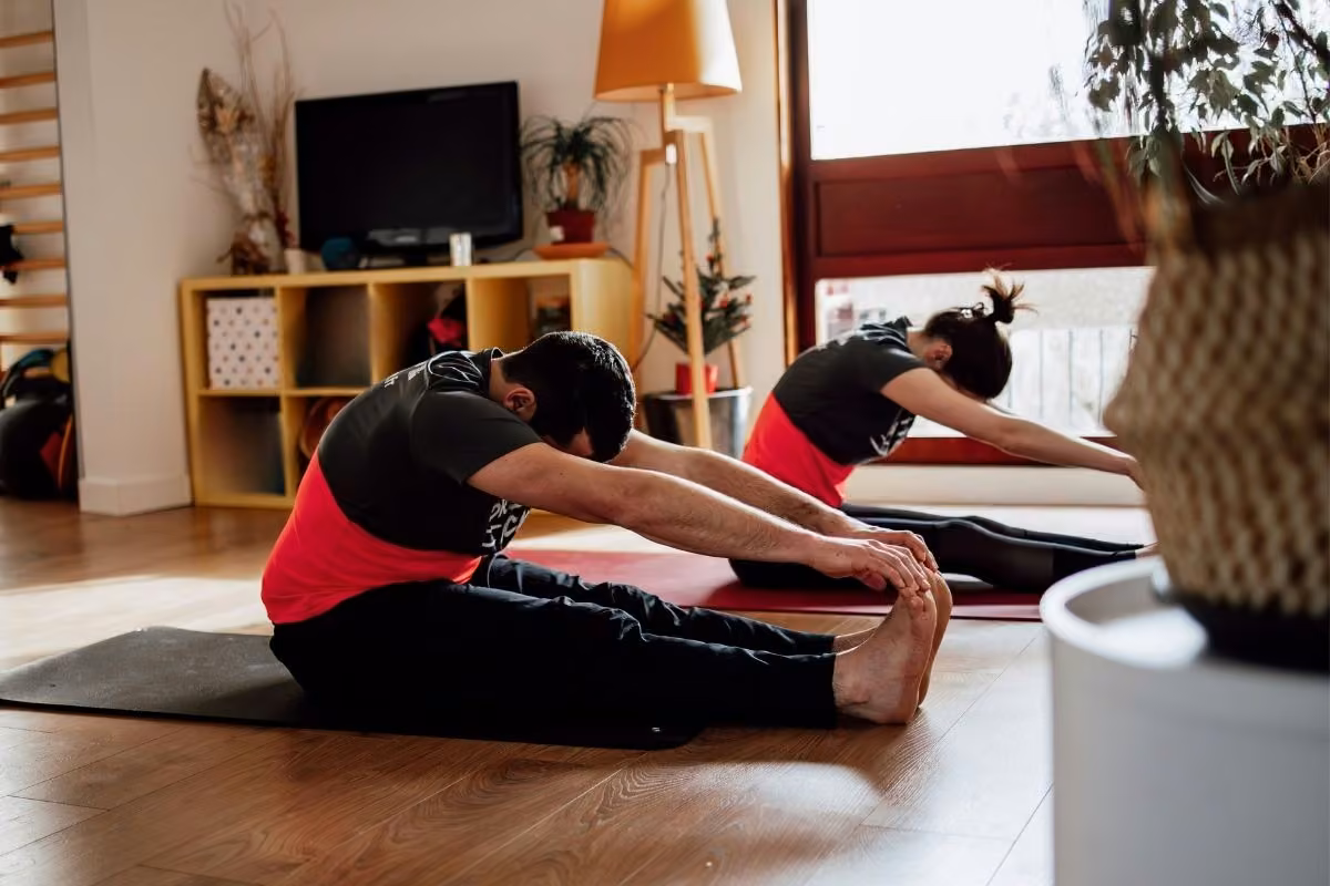 Flexion avant assise sur tapis, guidée par le coach