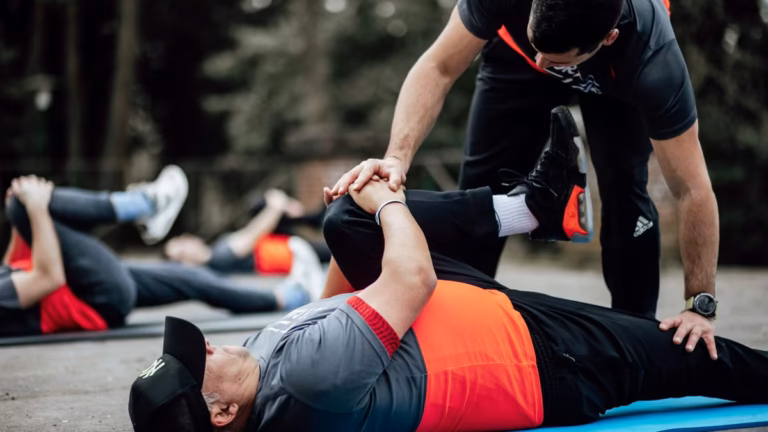Étirement genou vers la poitrine guidé par le coach, séance en plein air