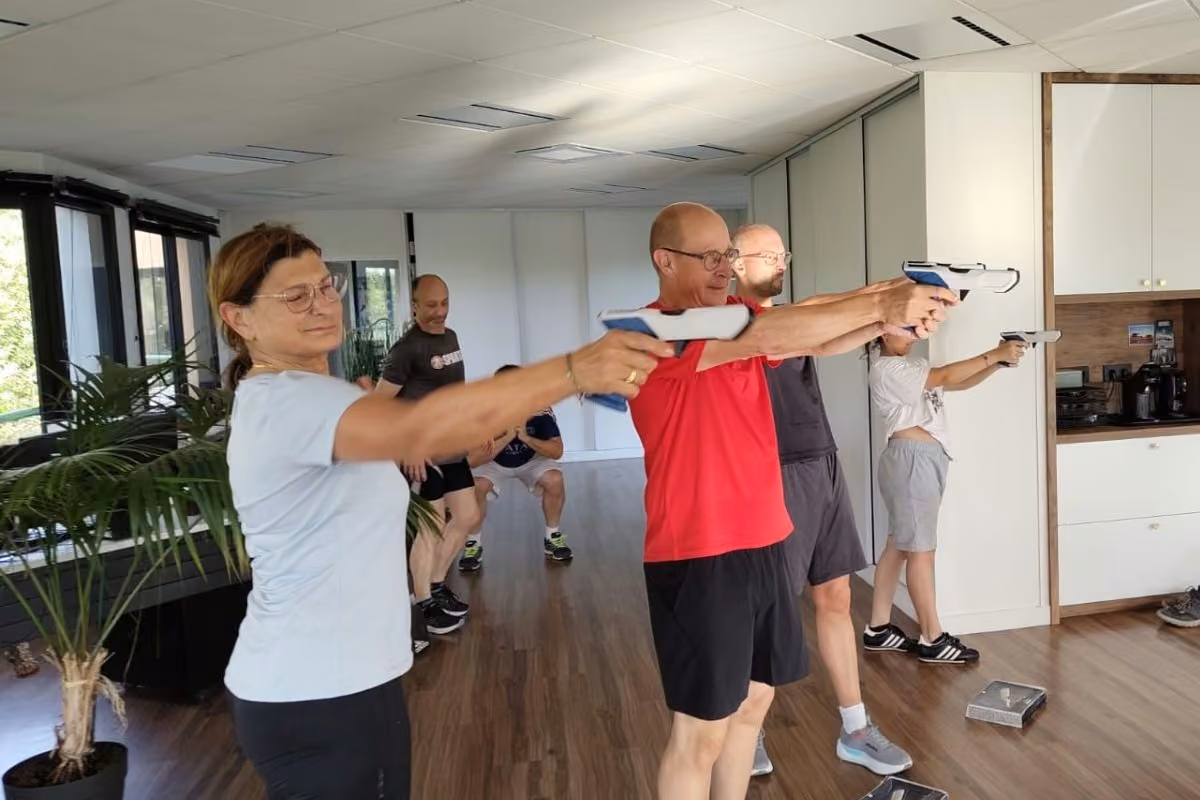 Séance de sport en entreprise dans un bureau lumineux, exercice debout en équipe